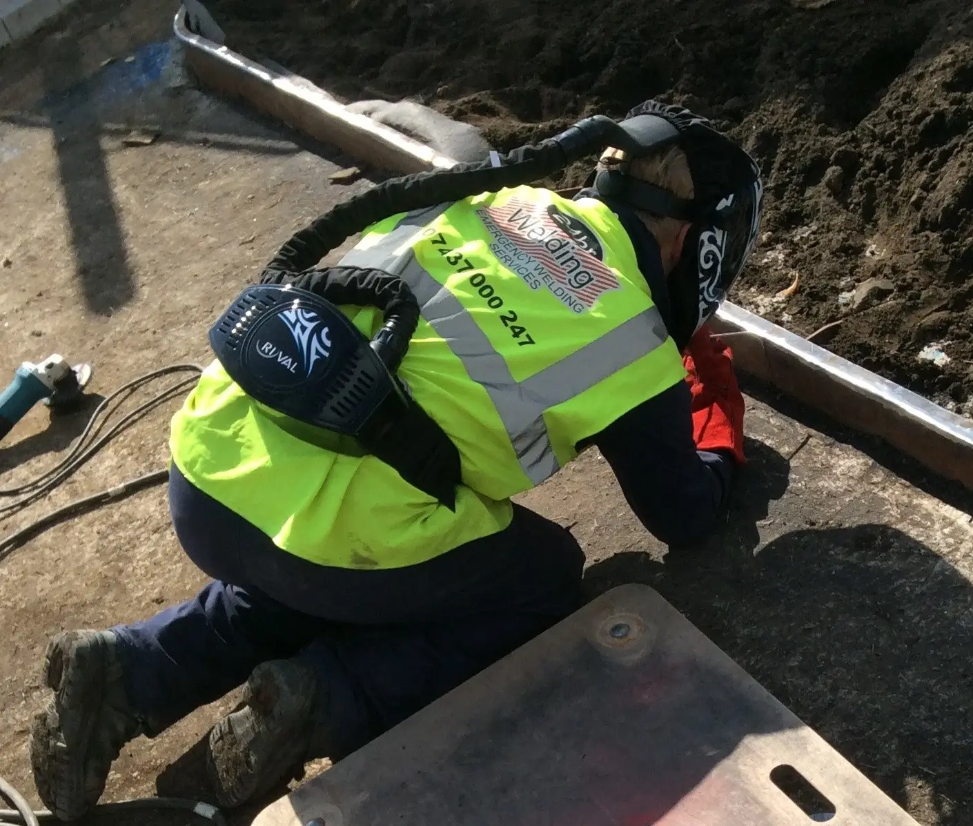 Railway line repair, welding team member undertaking repair with high vis logo vest and helmet, 24 Hour Welding